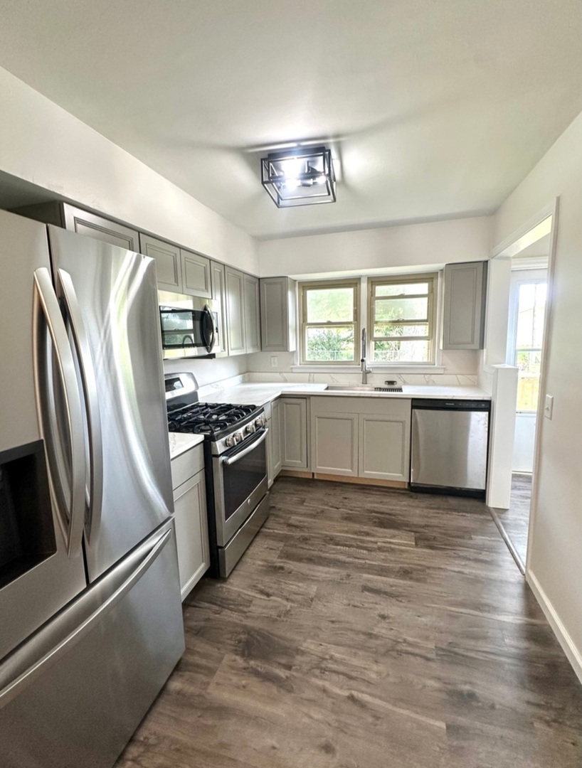 906 West Walnut Street Kankakee, IL 60901 - Photo 5 of 14 a kitchen with stainless steel appliances granite countertop a refrigerator a sink dishwasher a stove with white cabinets