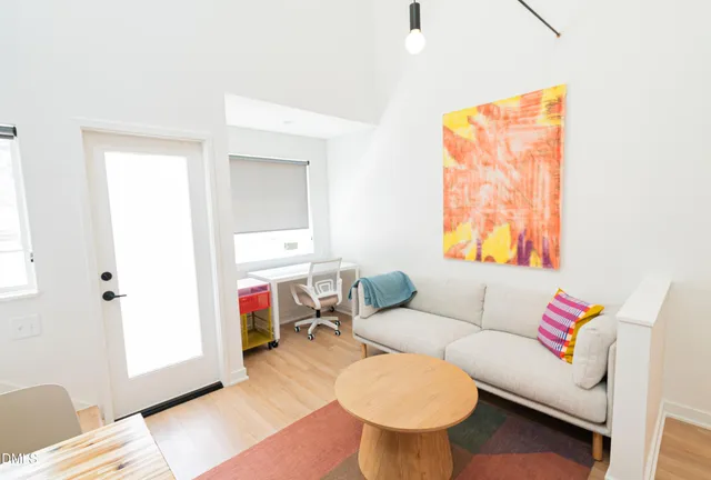 a living room with furniture a flat screen tv and a window