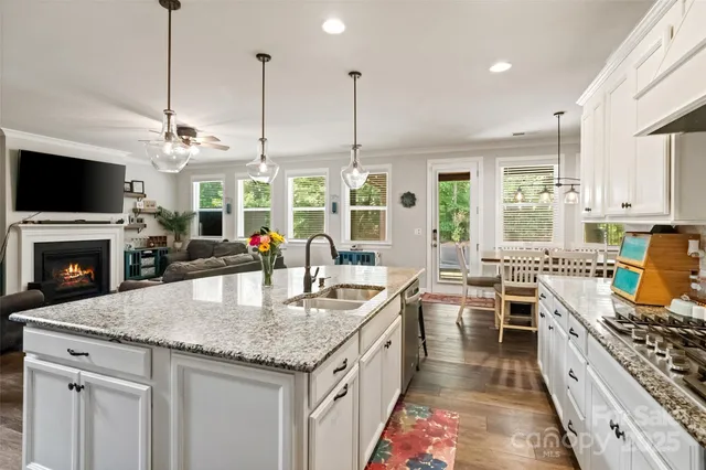 a kitchen with stainless steel appliances granite countertop a sink a center island and a refrigerator