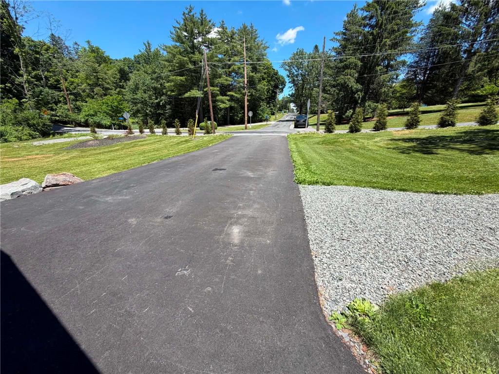 164 Sand Spring Road Cresco, PA 18326 - Photo 57 of 60 A gracefully paved driveway guides towards the road, bordered by neatly manicured lawns and natural rock accents.