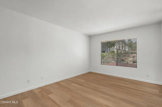 an empty room with wooden floor and sliding door