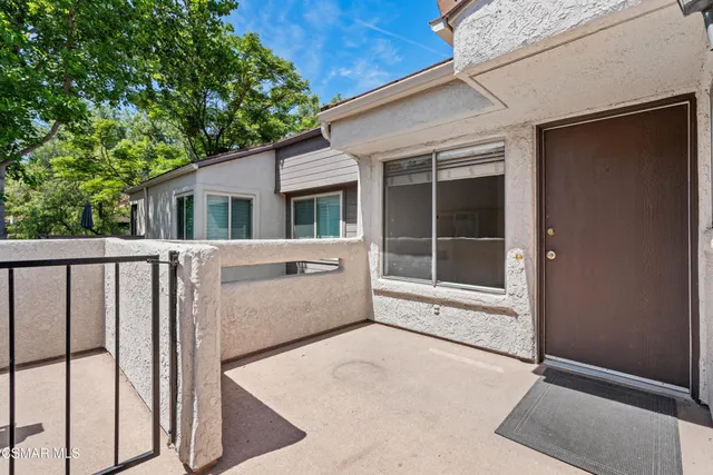 a view of a house with a large window and wooden fence