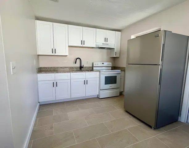 a kitchen with stainless steel appliances granite countertop a refrigerator sink and cabinets