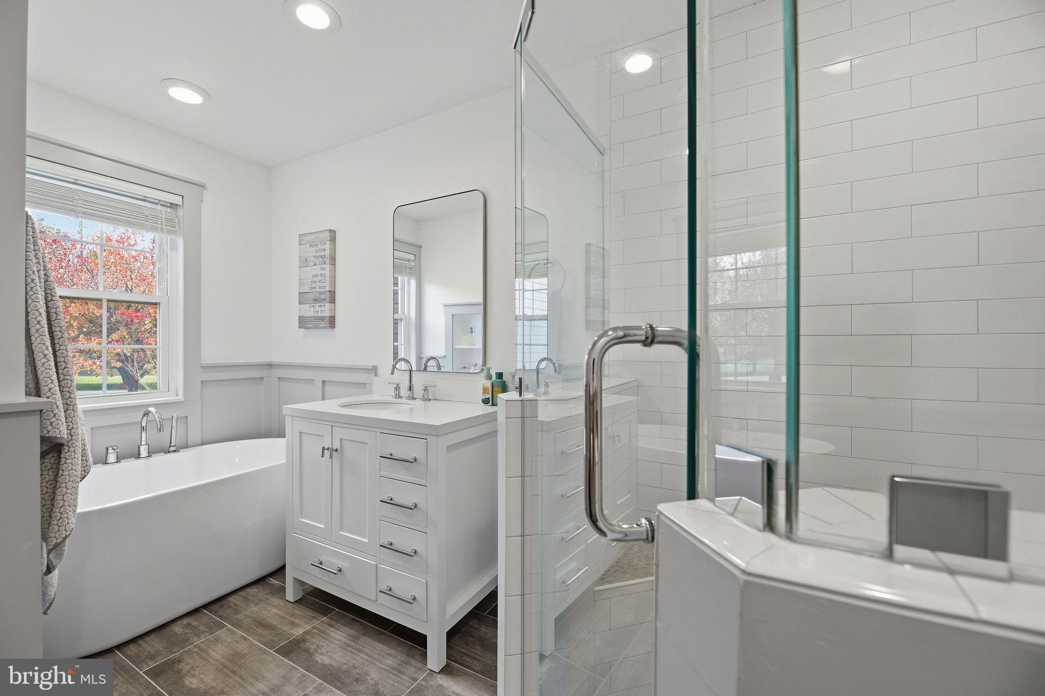 1719 Lottie Fowler Road Prince Frederick, MD 20678 - Photo 18 of 62 a bathroom with a double vanity sink a mirror and a bathtub