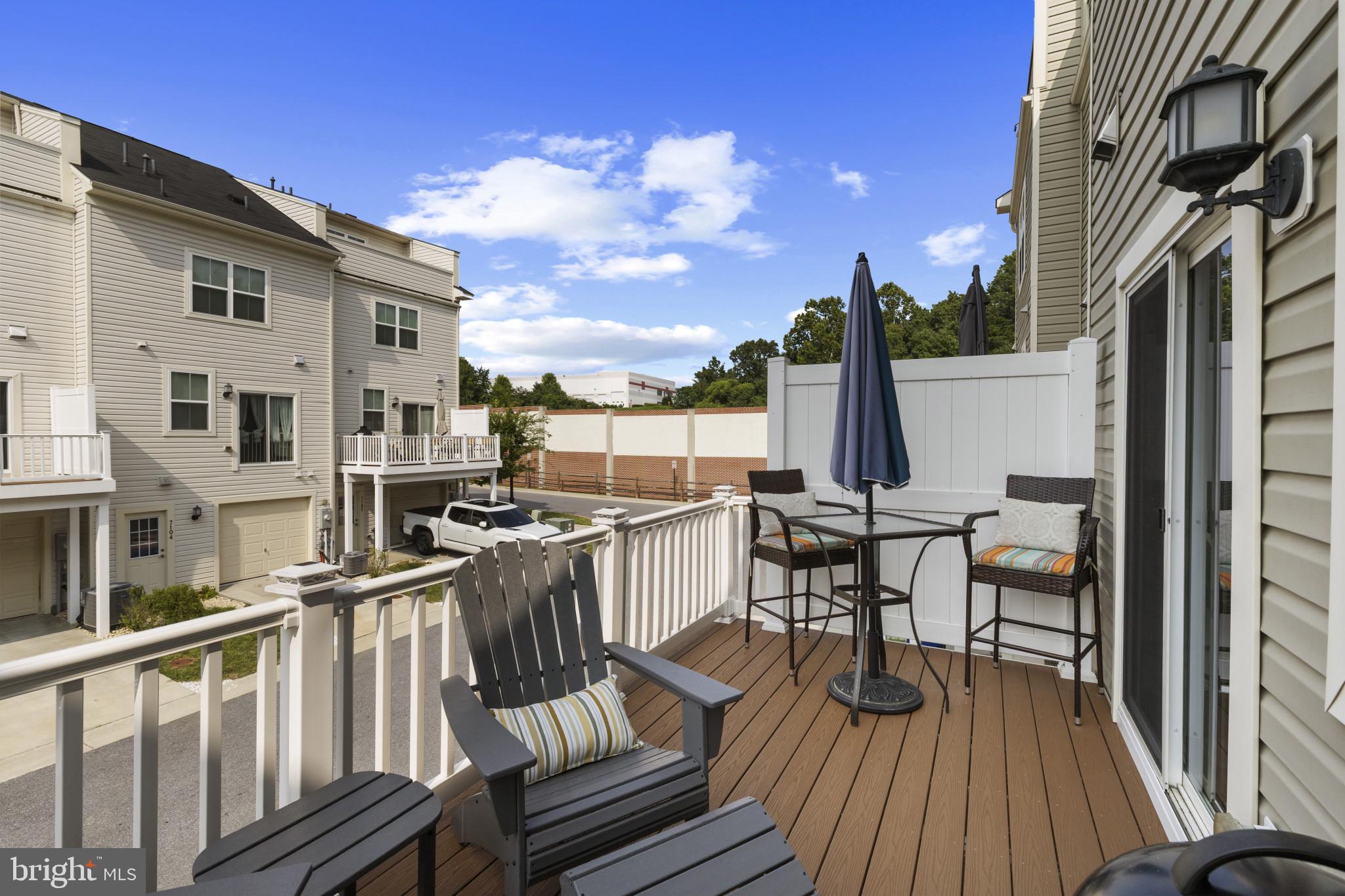 7107 Littlemore Way Hanover, MD 21076 - Photo 16 of 39 a view of a roof deck with table and chairs a barbeque with wooden floor and fence