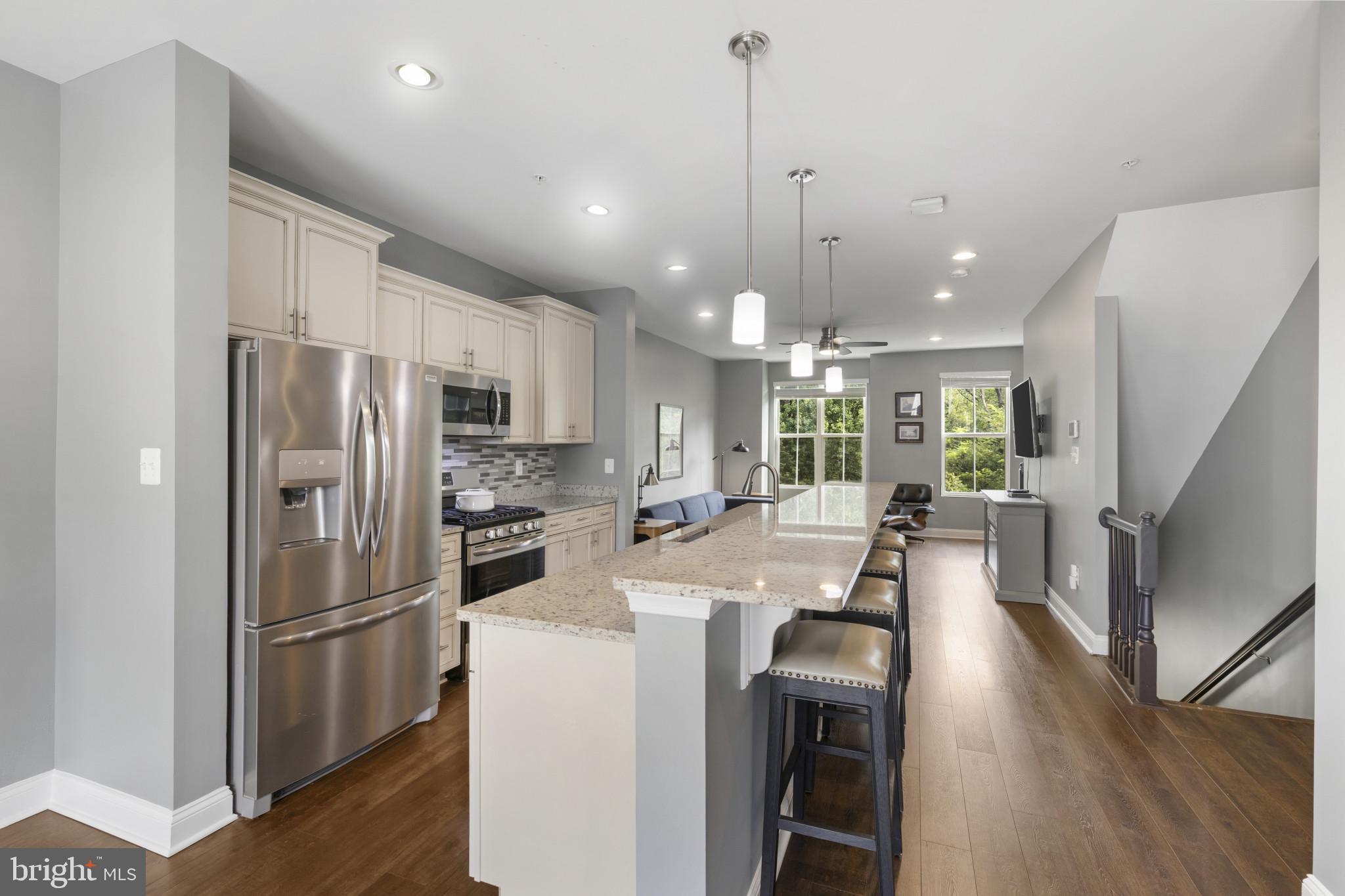 7107 Littlemore Way Hanover, MD 21076 - Photo 17 of 39 a kitchen with stainless steel appliances a refrigerator a stove a sink dishwasher a oven with white cabinets and wooden floor