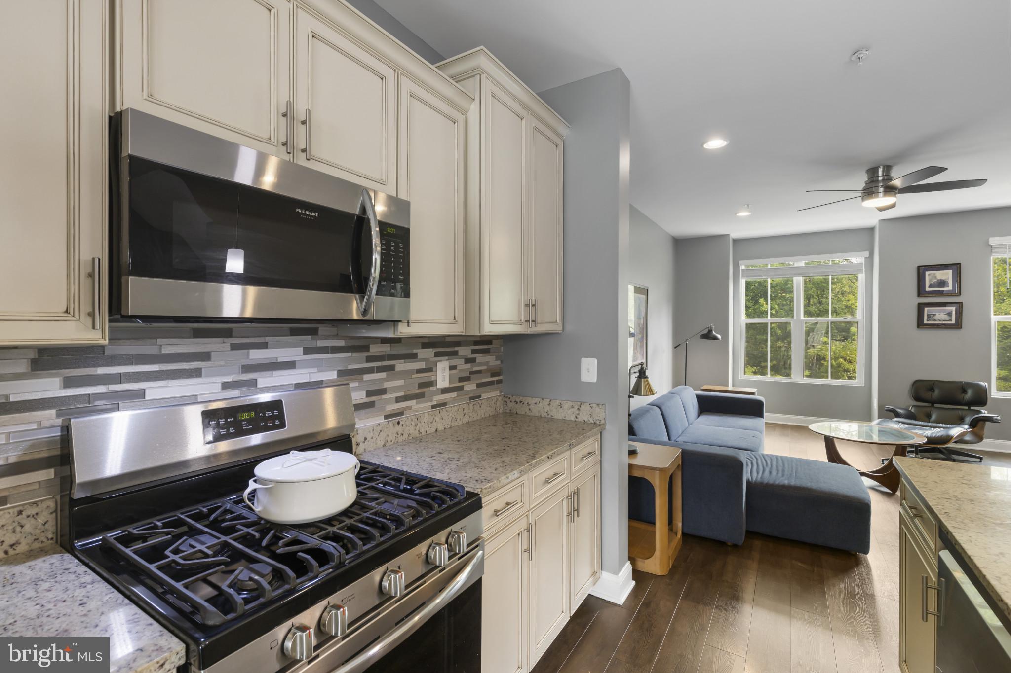 7107 Littlemore Way Hanover, MD 21076 - Photo 18 of 39 a kitchen with stainless steel appliances a stove a sink cabinets and a wooden floor