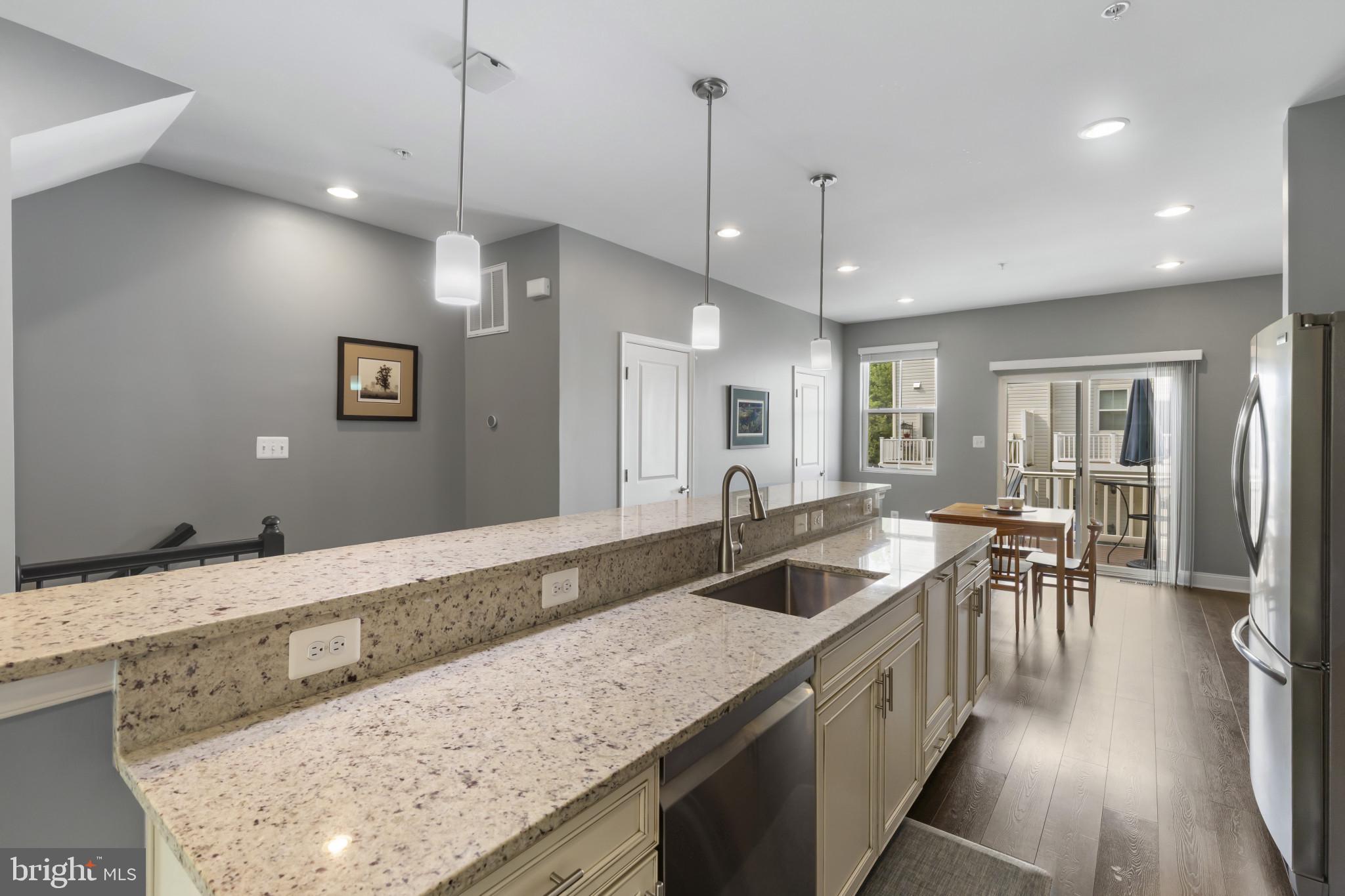 7107 Littlemore Way Hanover, MD 21076 - Photo 19 of 39 a kitchen with granite countertop a sink a counter top space and living room view