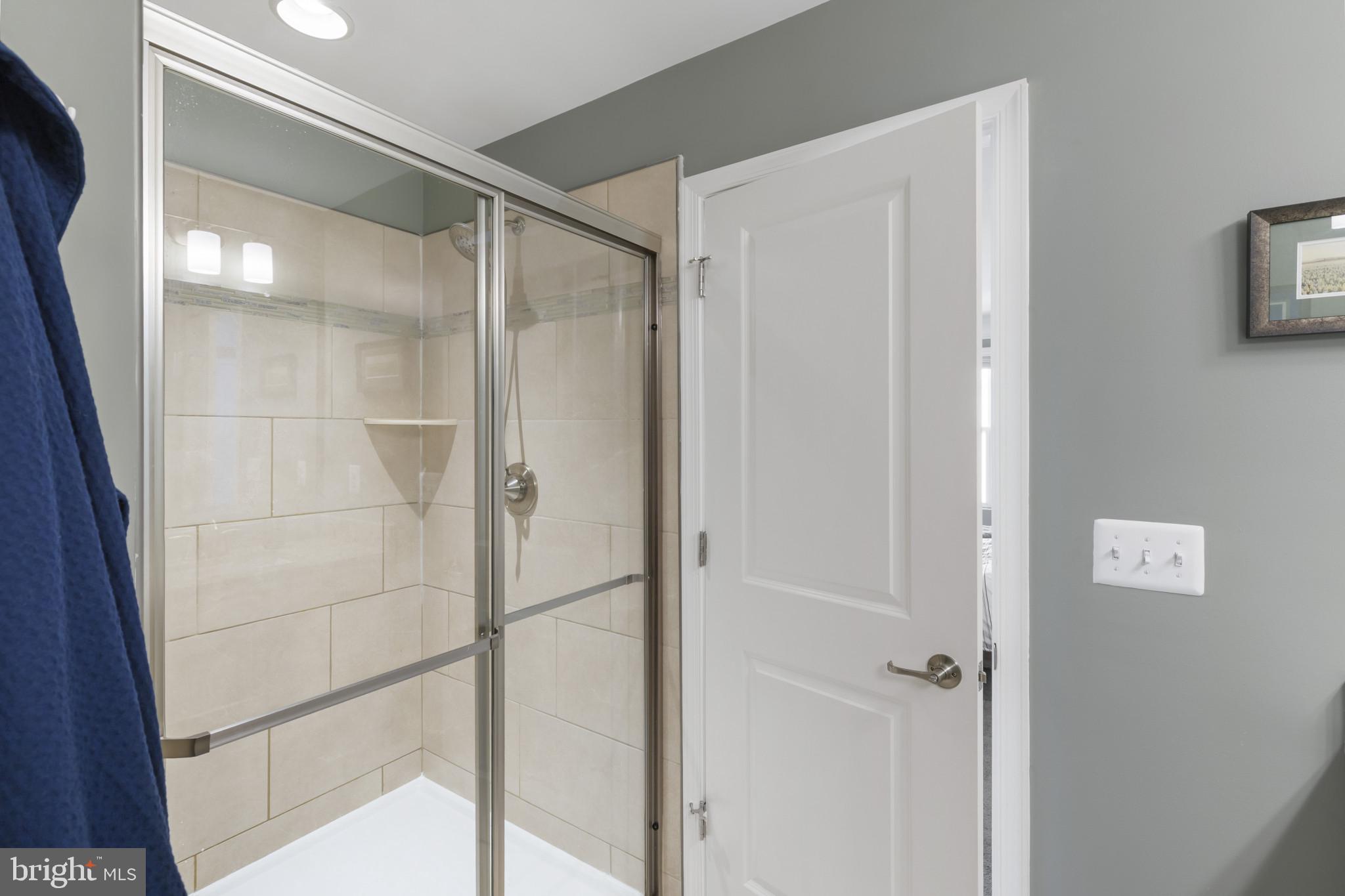 7107 Littlemore Way Hanover, MD 21076 - Photo 25 of 39 a bathroom with a glass shower door