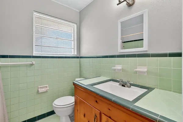 a bathroom with a sink toilet and mirror