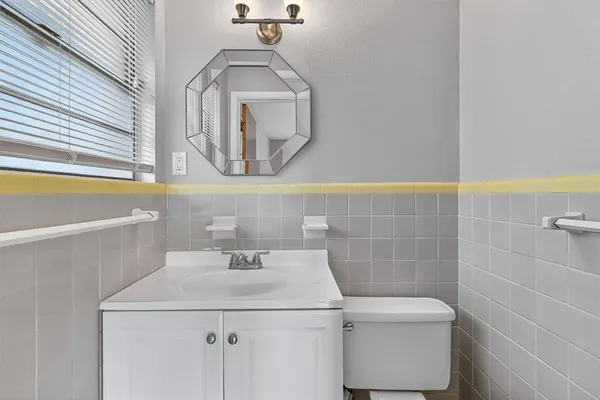 a bathroom with a sink a toilet and a mirror