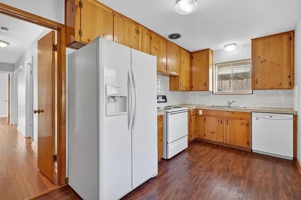 a kitchen with a refrigerator a sink and cabinets