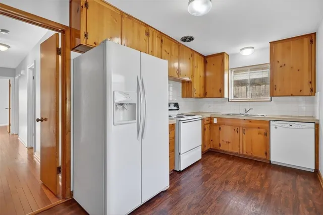 a kitchen with a refrigerator a sink and cabinets