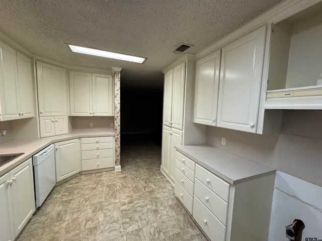 a kitchen with granite countertop white cabinets and white appliances