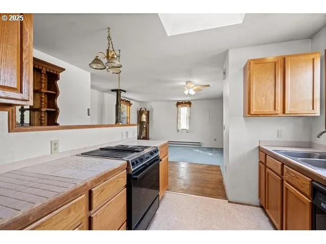 a kitchen with stainless steel appliances granite countertop a stove a sink dishwasher and cabinets with wooden floor