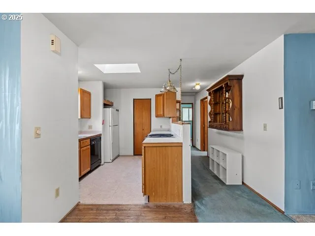 a view of living room kitchen with stainless steel appliances cabinets