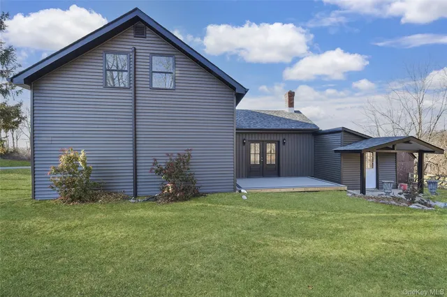 a view of a yard in front of a house with large windows
