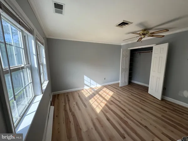 a view of empty room with window and ceiling fan