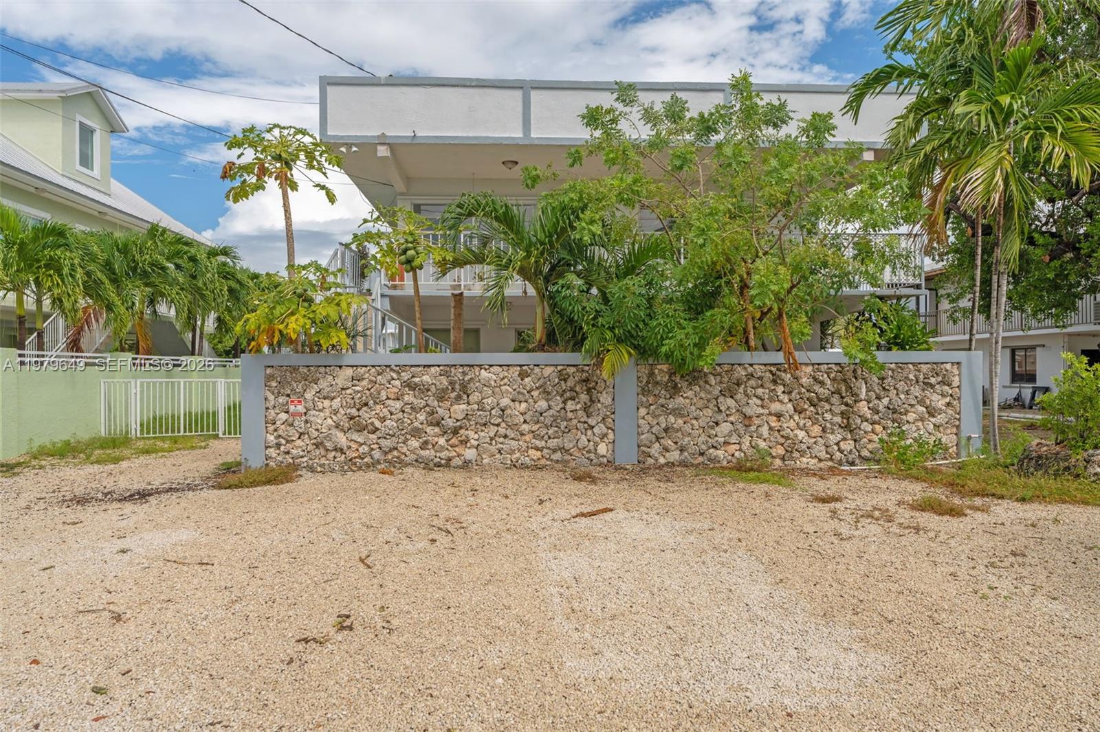 174 Corrine Place, Unit 1 Key Largo, FL 33037 - Photo 2 of 17 a view of a yard with a brick wall