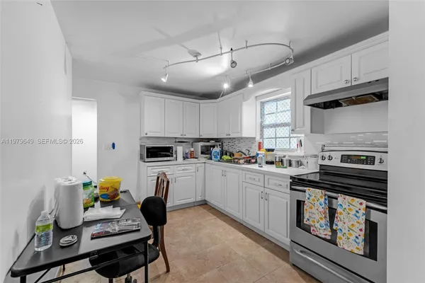 a kitchen with cabinets appliances and a window