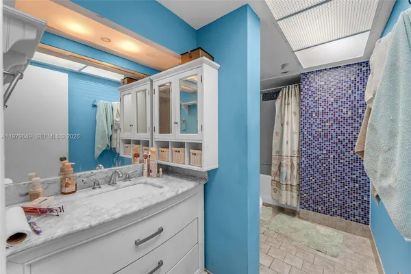 a bathroom with a granite countertop sink and a mirror