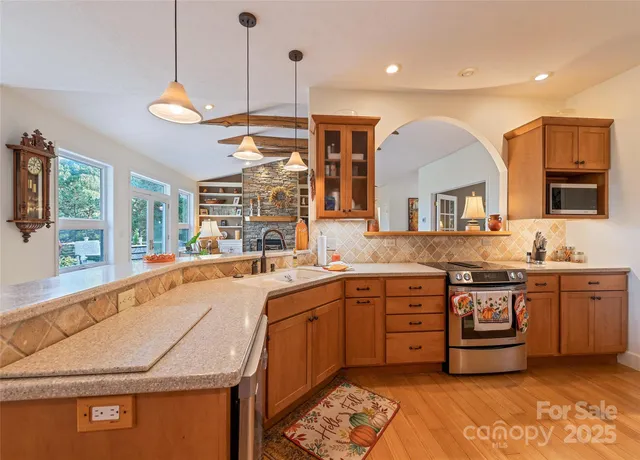a large kitchen with stainless steel appliances granite countertop a stove a sink and a refrigerator