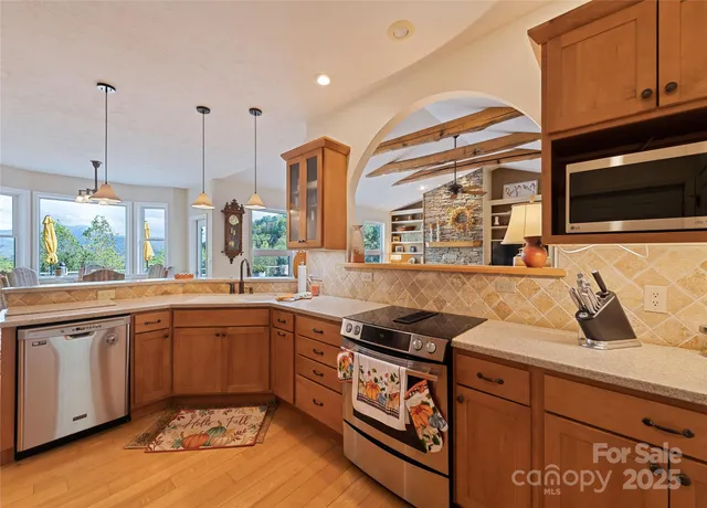 a kitchen with stainless steel appliances granite countertop a sink a stove and a microwave