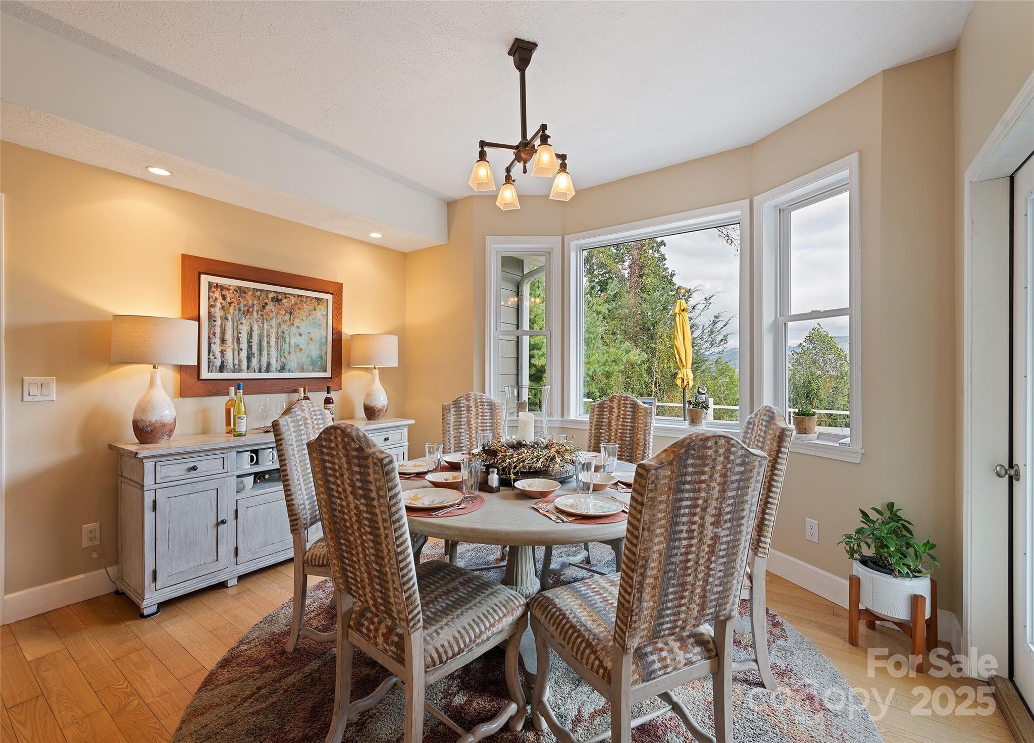 966 Coyote Hollow Road Waynesville, NC 28785 - Photo 13 of 29 a view of a dining room with furniture large windows and wooden floor