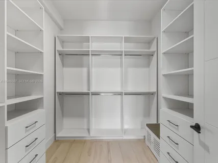 a view of walk in closet with empty racks