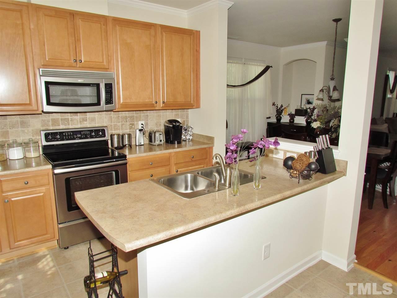 2916 Casona Way Raleigh, NC 27616 - Photo 13 of 25 a kitchen with a sink a microwave and cabinets