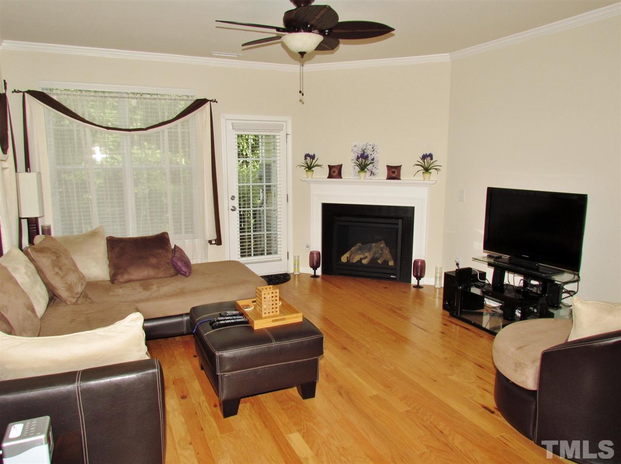 2916 Casona Way Raleigh, NC 27616 - Photo 6 of 25 a living room with furniture a fireplace and a flat screen tv