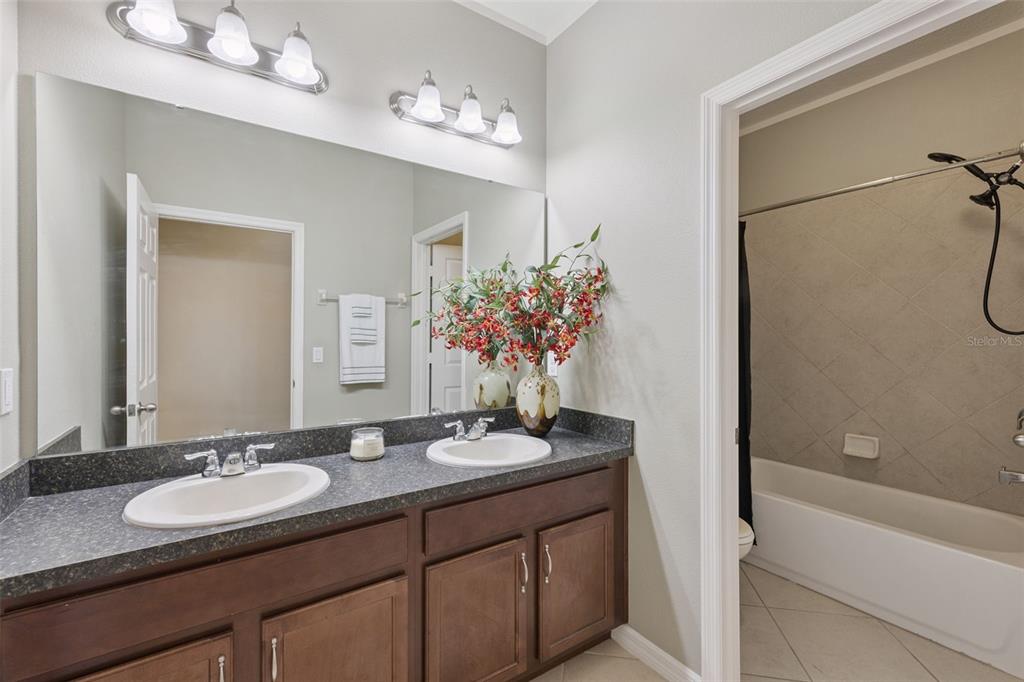 3940 Pine Gate Trail Orlando, FL 32824 - Photo 15 of 36 a bathroom with a granite countertop sink and a mirror