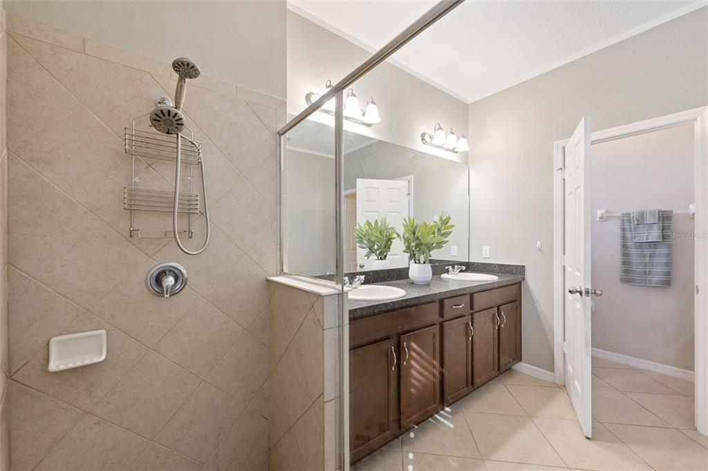 3940 Pine Gate Trail Orlando, FL 32824 - Photo 19 of 36 a bathroom with a granite countertop sink a shower and a mirror