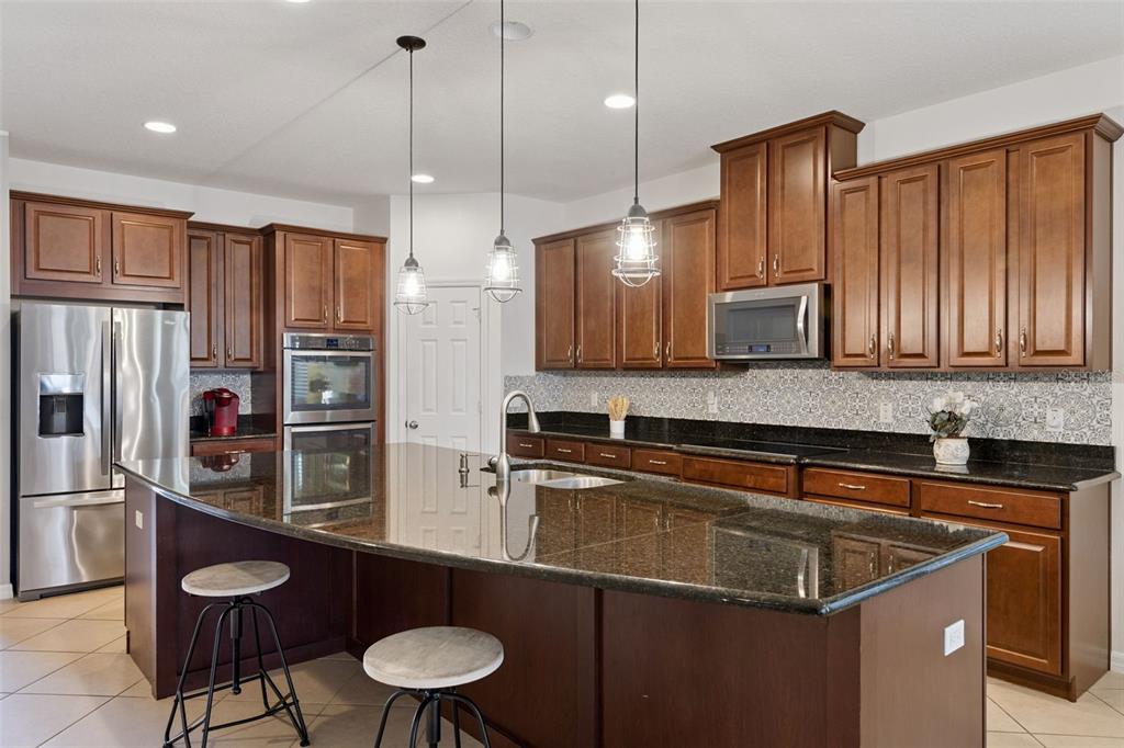 3940 Pine Gate Trail Orlando, FL 32824 - Photo 4 of 36 a kitchen with a sink a kitchen island and stainless steel appliances