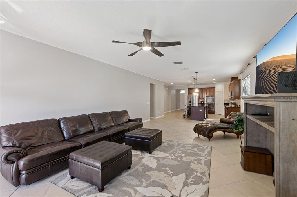 3940 Pine Gate Trail Orlando, FL 32824 - Photo 9 of 36 a living room with fireplace furniture and a ceiling fan