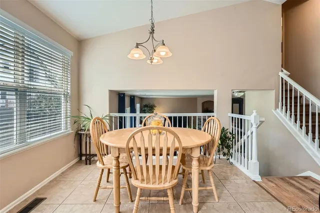 a dining room with furniture a chandelier and window