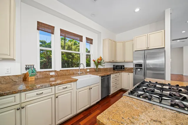 a kitchen with granite countertop white cabinets and white stainless steel appliances