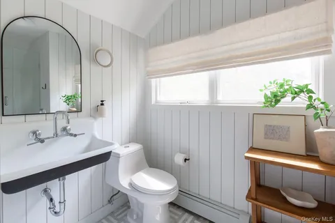 a bathroom with a sink a toilet and a mirror