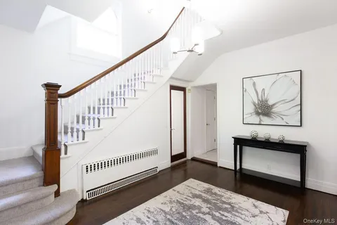 a view of staircase with white walls and a rug