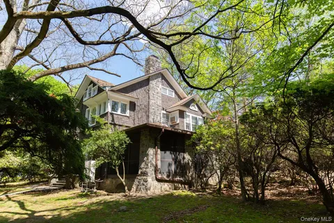a view of a white house with a big yard and a large tree