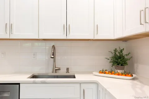 a kitchen with stainless steel appliances granite countertop a sink and a white cabinets