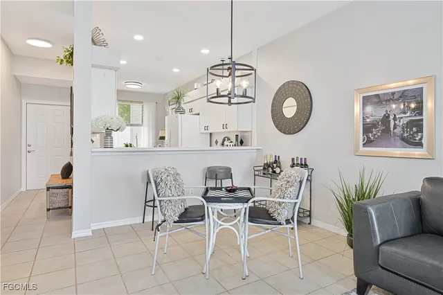 a dining room filled chandelier and kitchen view