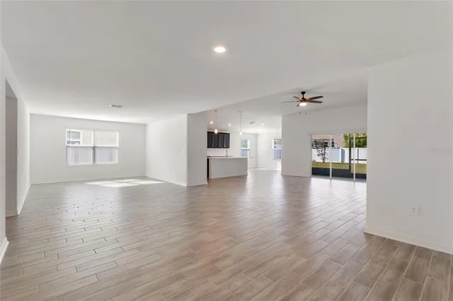 a view of an empty room with a windows and wooden floor