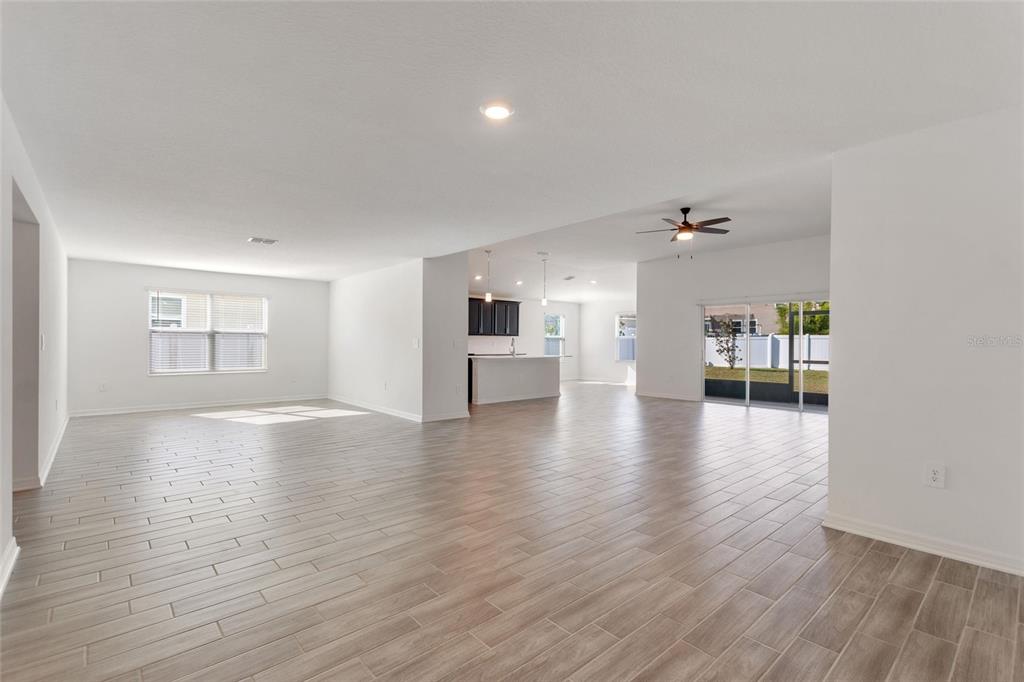 5767 Talc St Mount Mount Dora, FL 32757 - Photo 14 of 44 a view of an empty room with a windows and wooden floor