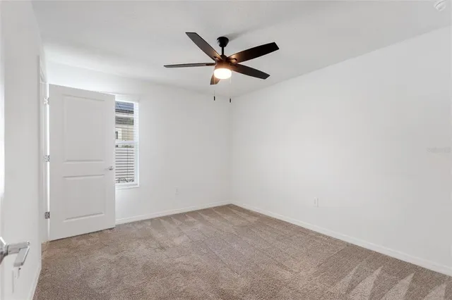 an empty room with closet and ceiling fan