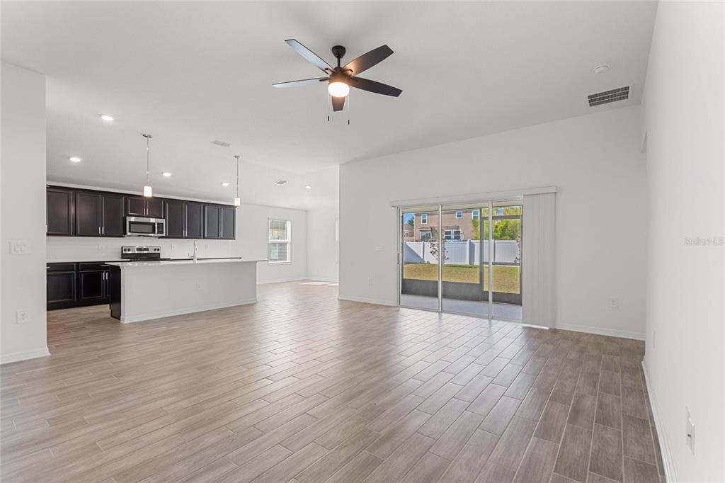 5767 Talc St Mount Mount Dora, FL 32757 - Photo 19 of 44 a view of an empty room with a window and wooden floor