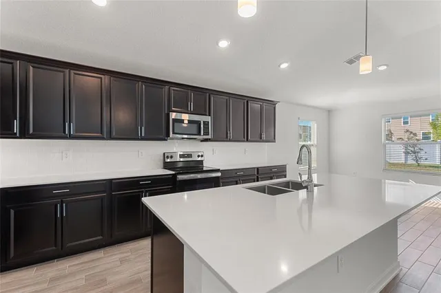 a kitchen with stainless steel appliances granite countertop a sink a stove and microwave