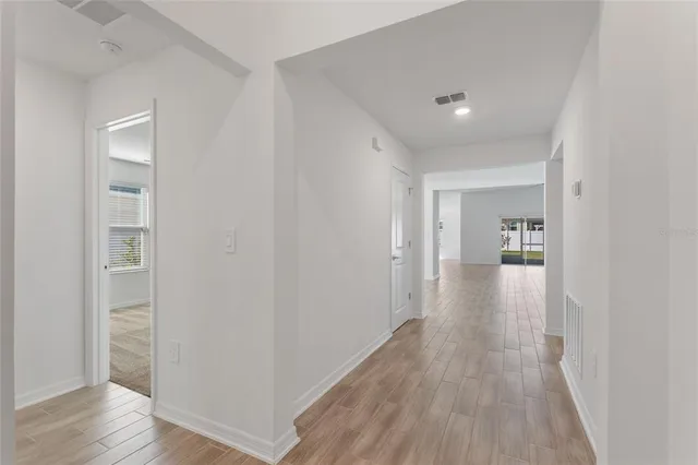a view of a hallway with wooden floor