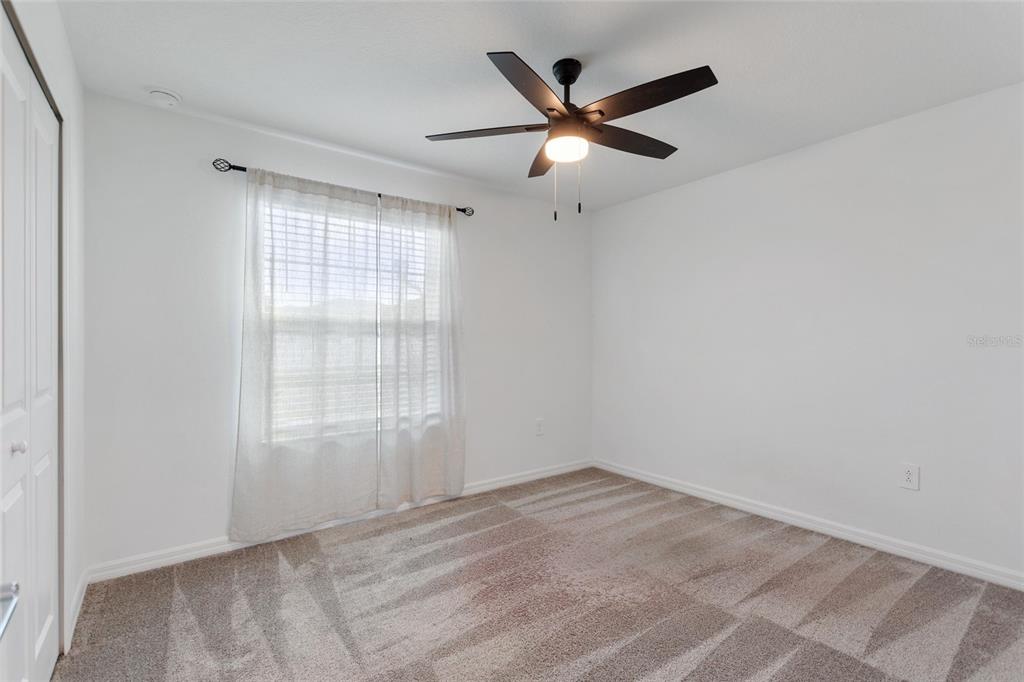 5767 Talc St Mount Mount Dora, FL 32757 - Photo 5 of 44 an empty room with wooden floor and windows