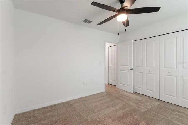 an empty room with chandelier fan